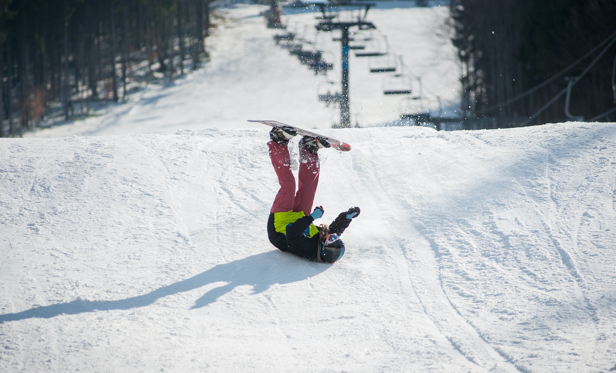 Snowboarder falls on the slopes during the descent Snowboarder falls on the slopes during the descent