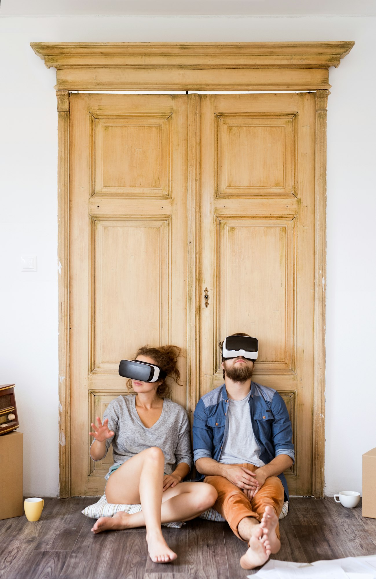Young couple wir VR glasses moving in new house. Young couple wir VR glasses moving in new house.
