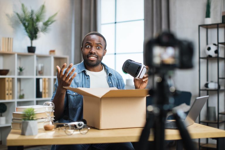 African american man opening parcel box and recording video