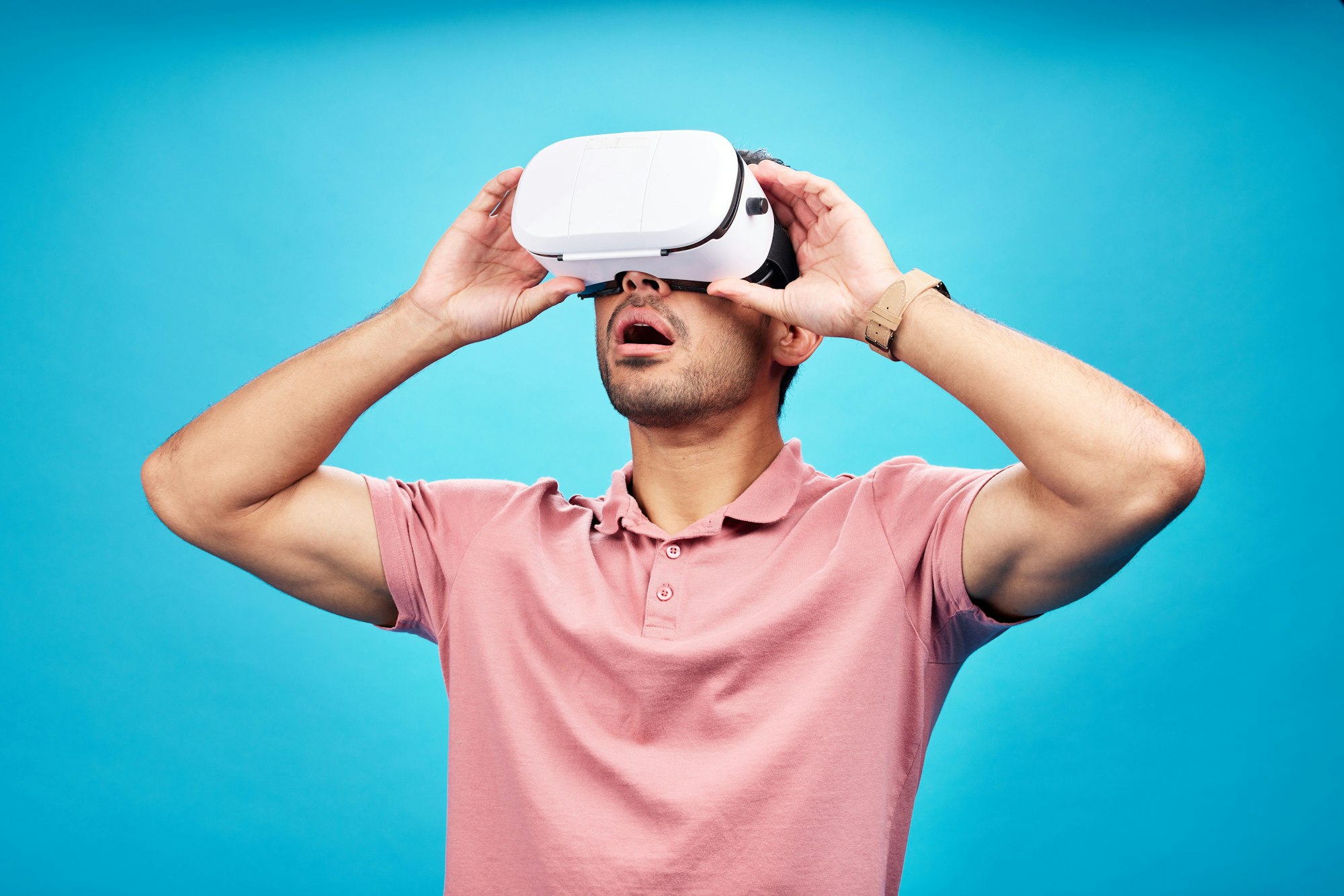 Man, virtual reality and surprise with UX and metaverse, futuristic technology isolated on blue bac